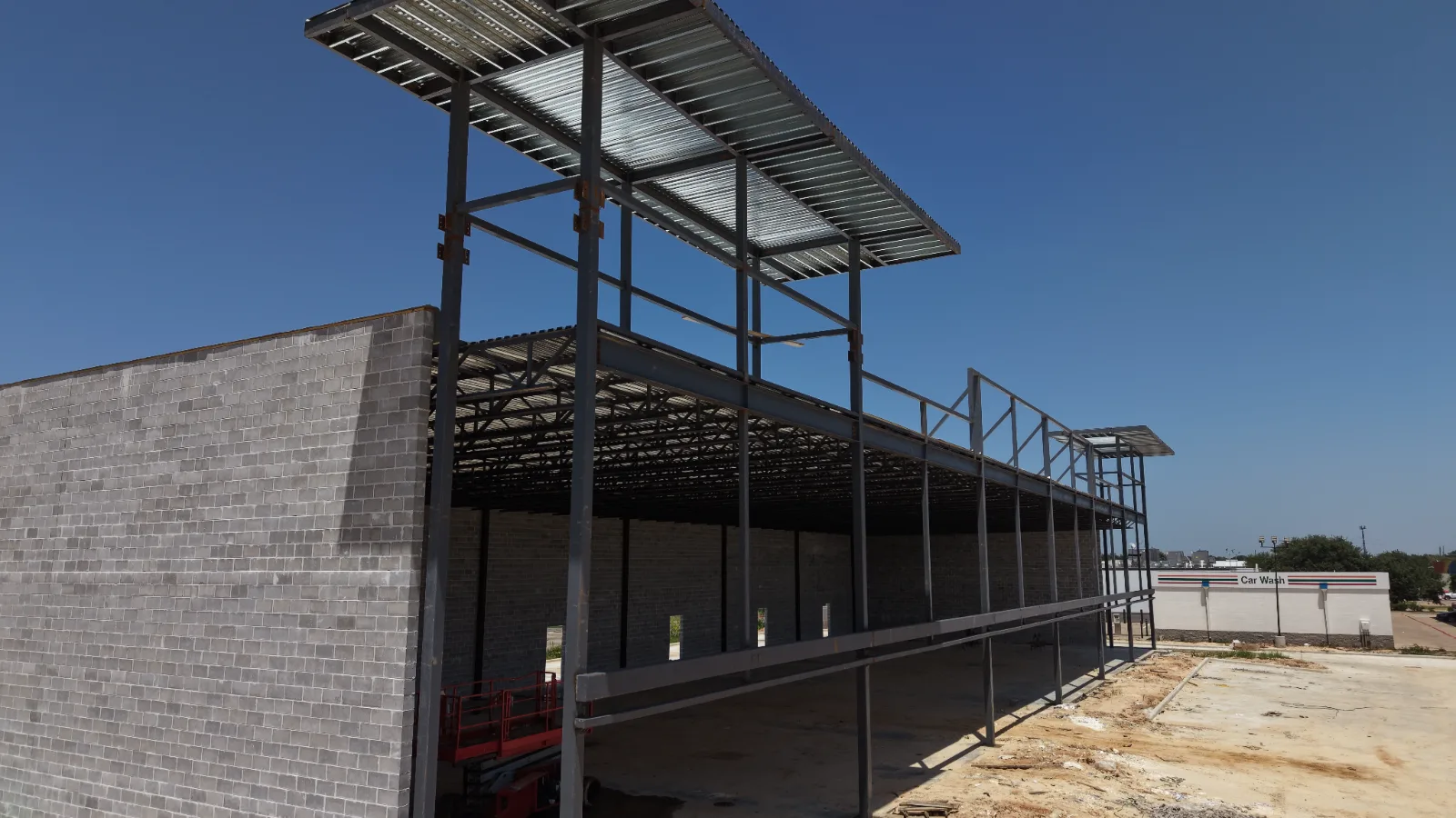 Steel canopy framing over a CMU shell at a Texas retail and fuel site